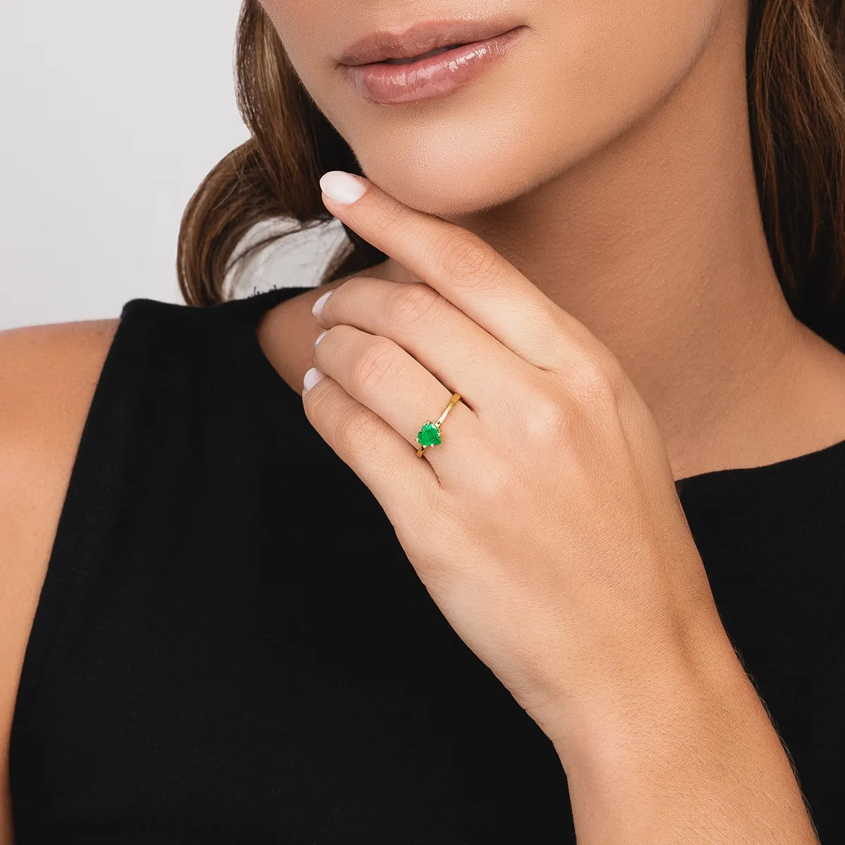 Anillo en oro amarillo de 18 Kilates, con esmeralda central de 0.60 Ct