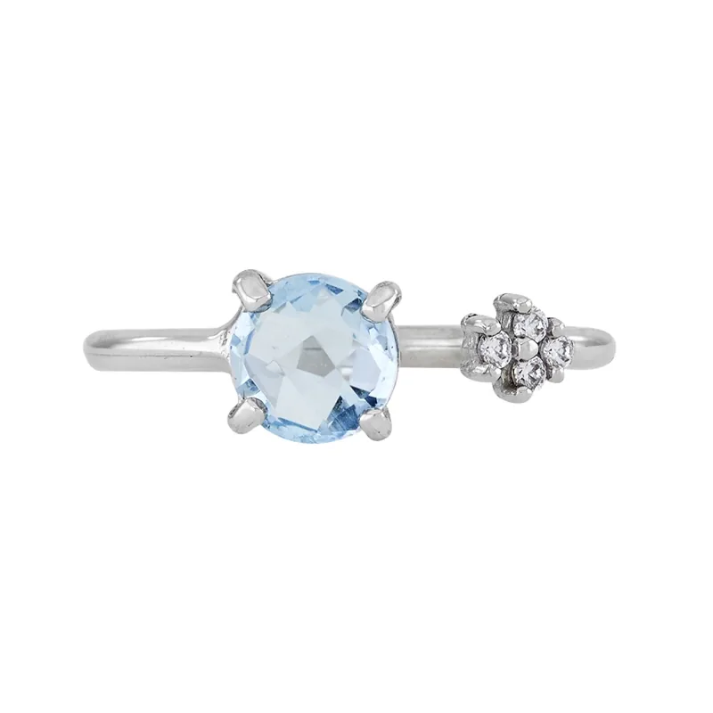 Anillo en oro blanco de 18 Kilates, con topacio central y decoración en zircones