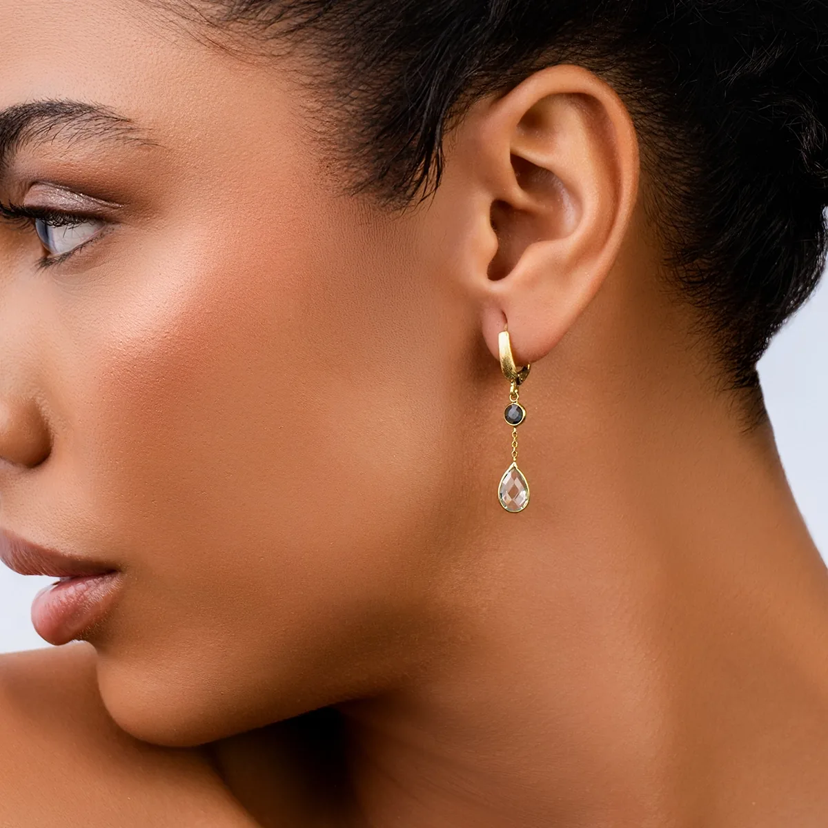 Aretes en oro amarillo de 18 Kilates satinado, Bisel+decoración, con 2 topacios centrales y decoración en zircones