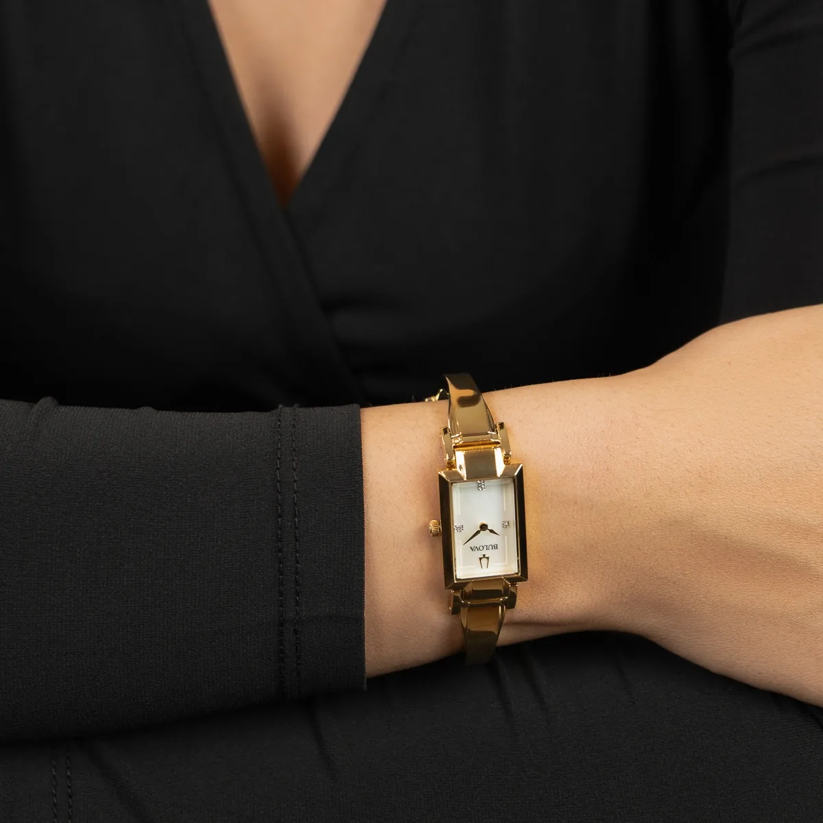 Reloj Bulova analogo, para Dama, tablero rectangular color blanco, estilo puntos, pulso acero color dorado
