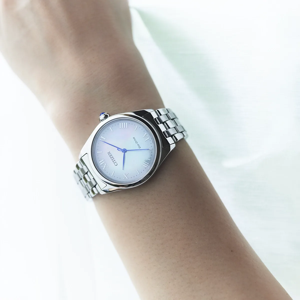 Reloj Citizen análogo, para Dama, tablero redondo color blanco, estilo index + romano, pulso acero color plateado