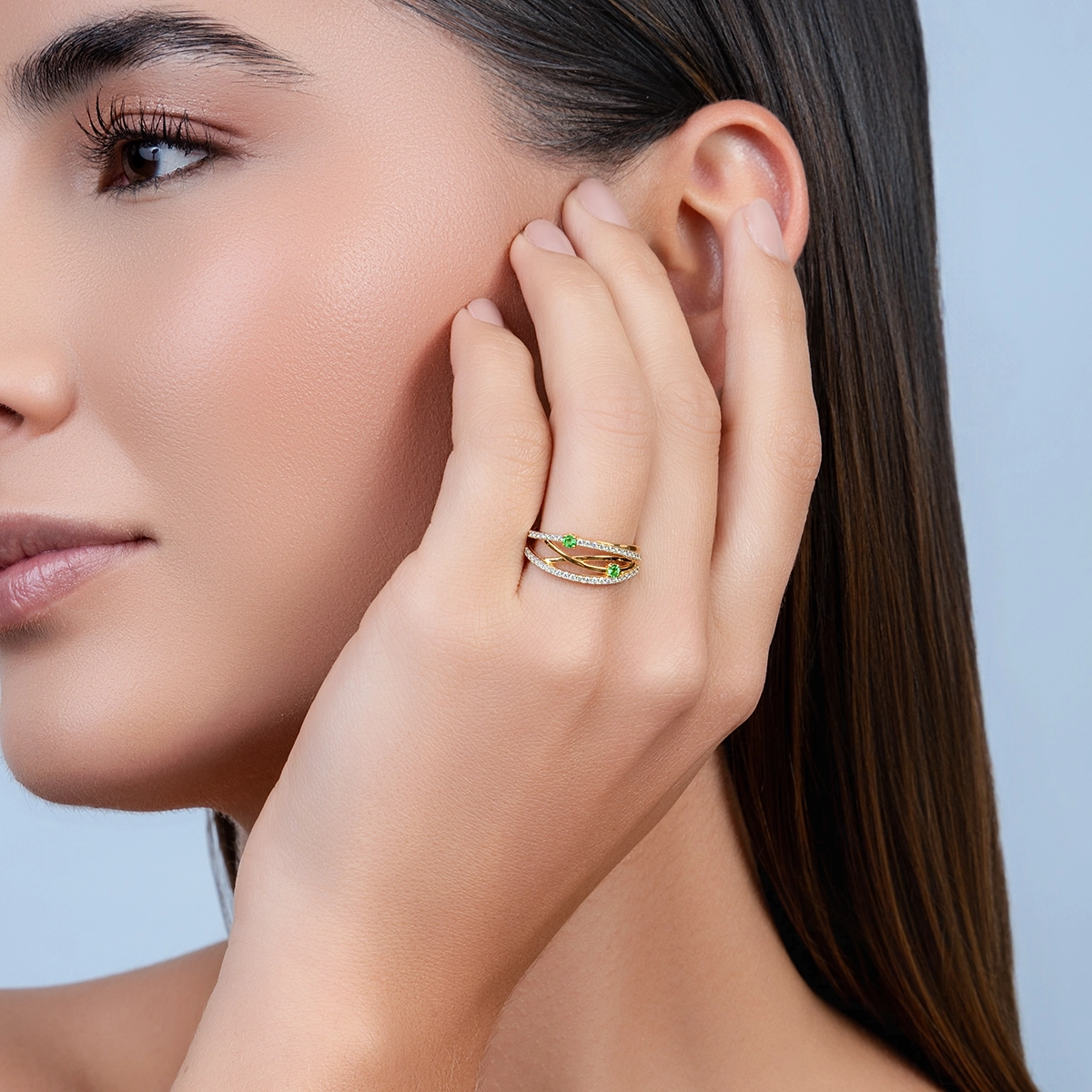 Anillo en oro amarillo de 18 Kilates, con 2 esmeraldas centrales de 0.08 Ct y decoración en diamantes de 0.20 Ct