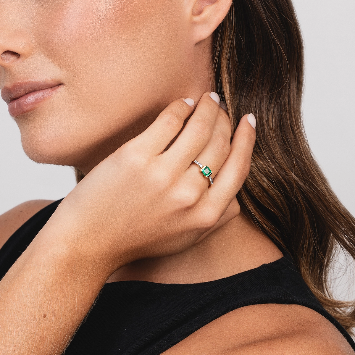 Anillo en oro amarillo de 18 Kilates, con esmeralda central de 0.65 Ct y decoración en diamantes de 0.07 Ct