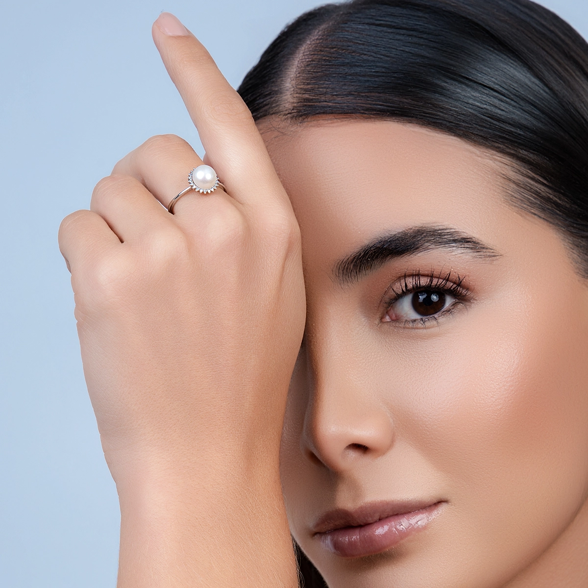 Anillo en oro blanco de 18 Kilates, con perla central de 7 mm de ancho aprox y decoración en diamantes de 0.07 Ct