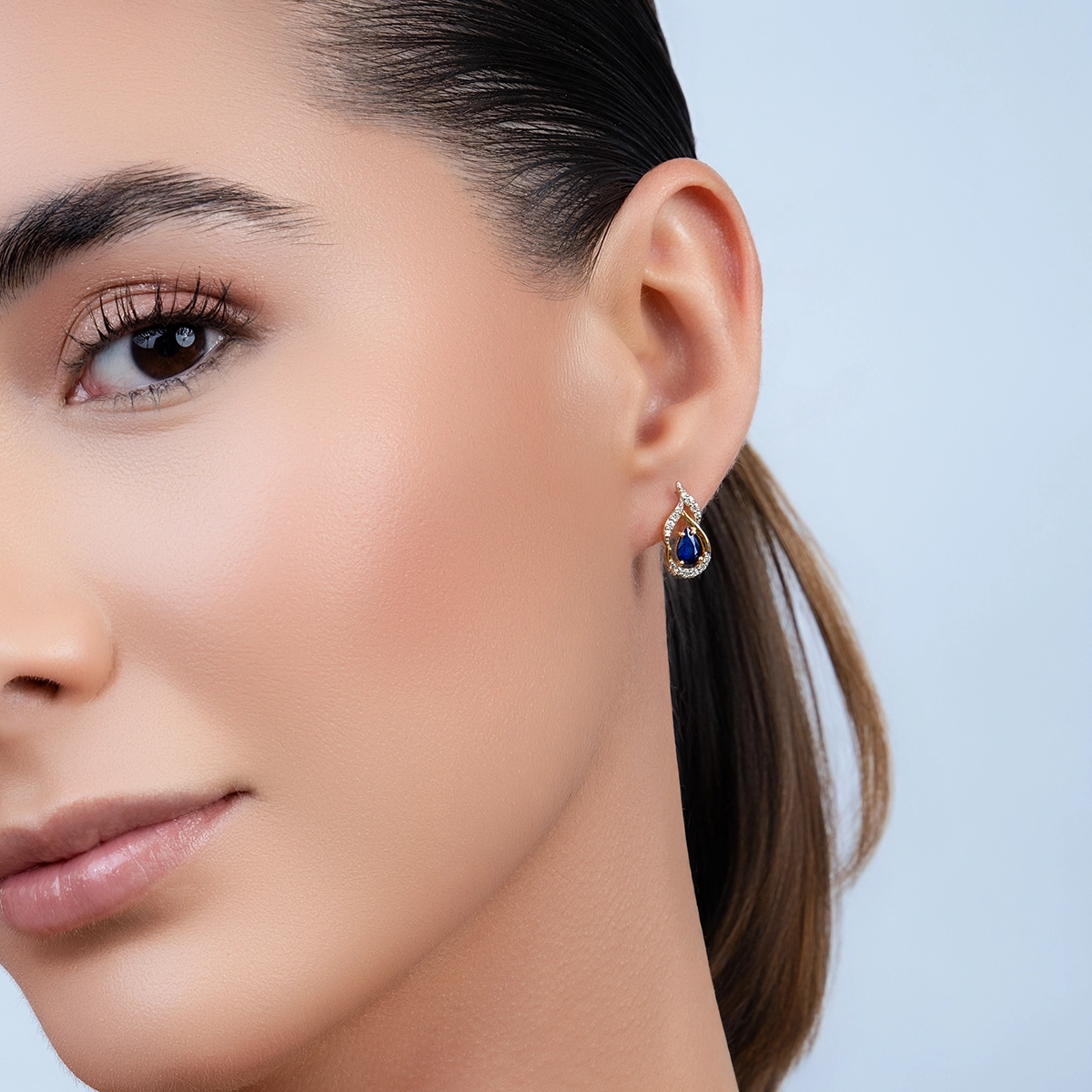 Aretes en oro amarillo de 18 Kilates, Onda, con 2 zafiros centrales de 0.75 Ct y decoración en diamantes de 0.18 Ct