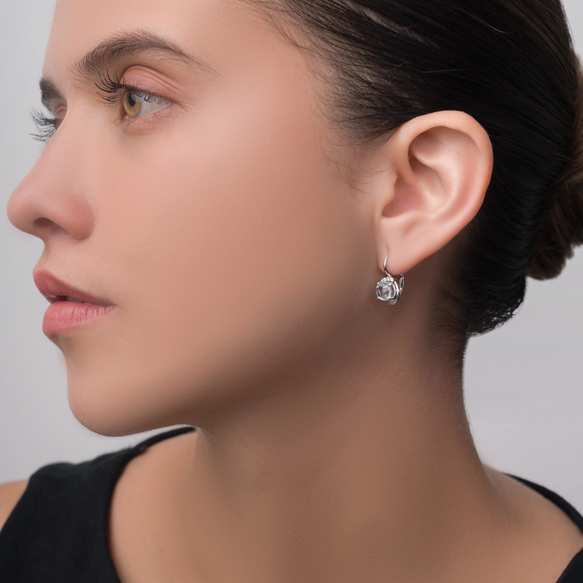 Aretes en oro blanco de 18 Kilates, Uñas+decoración, con 2 topacios centrales y decoración en zircones
