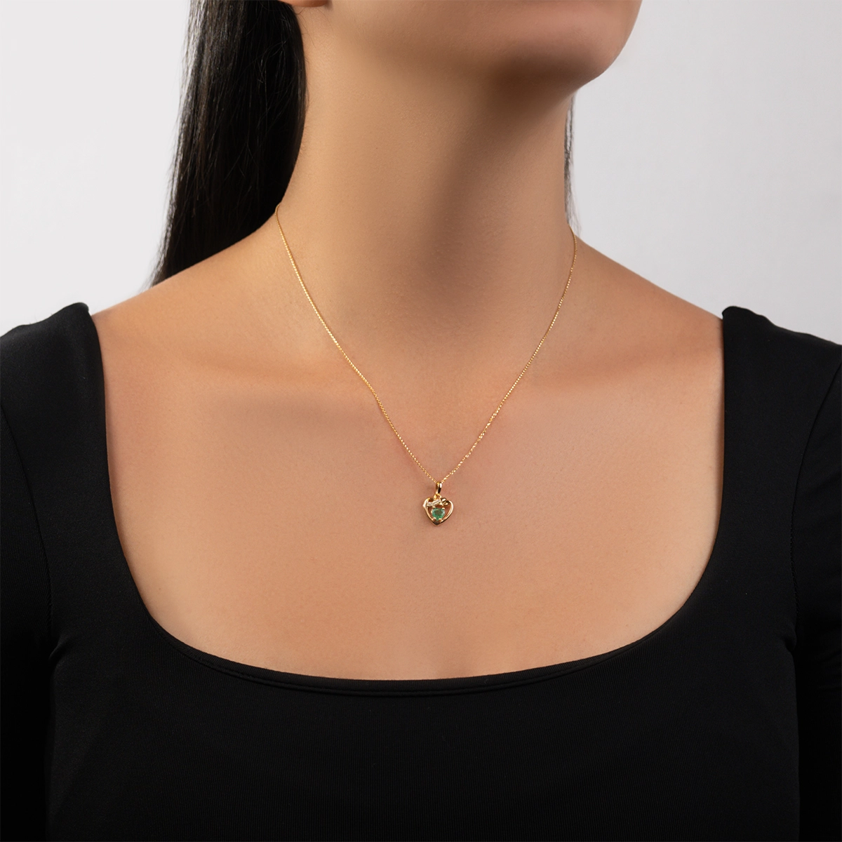 Dije de corazón en oro de 18 Kilates, con esmeralda central de 0.25 Ct y decoración en diamantes de 0.02 Ct