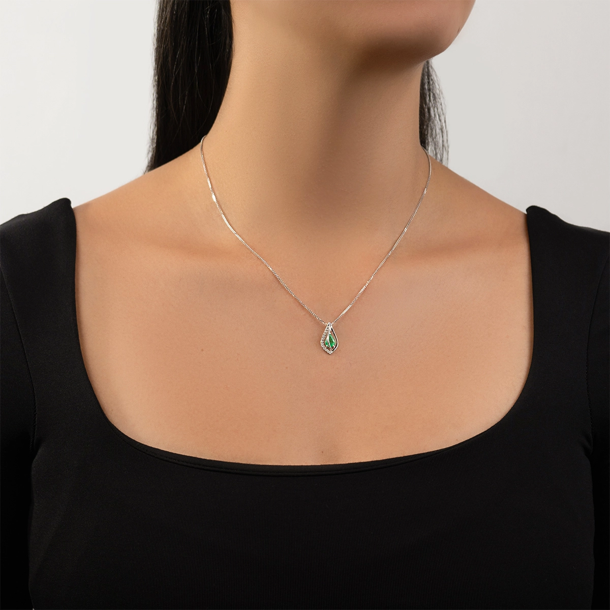 Dije en oro blanco de 18 Kilates, Lágrima, con esmeralda central de 0.70 Ct y decoración en diamantes de 0.06 Ct