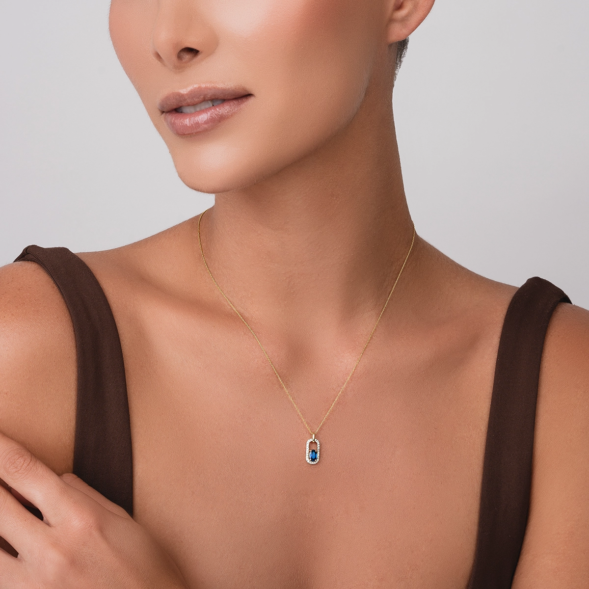 Gargantilla en oro amarillo de 18 Kilates, Figuras geométricas, con zafiro central de 0.56 Ct y decoración en diamantes de 0.12 Ct, 42 cm. de largo, 0.50 mm. de ancho