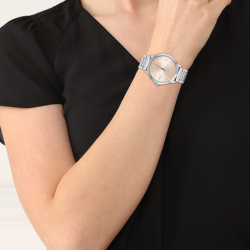 Reloj Lacoste analogo, para Dama, tablero redondo color rosa, estilo index + arabigo, pulso acero color plateado