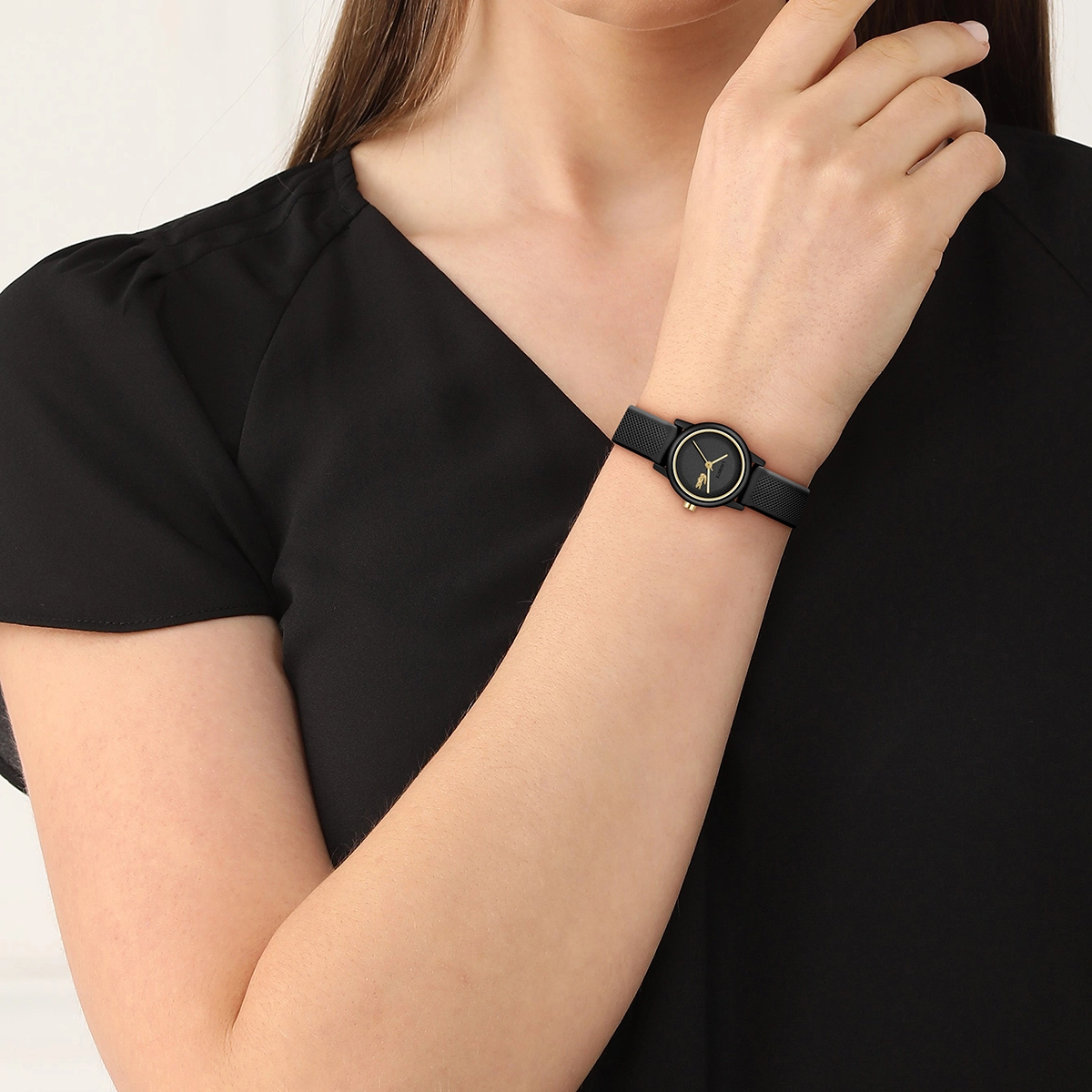 Reloj Lacoste análogo, para Dama, tablero redondo colores negro y dorado, estilo sin números, pulso silicona color negro