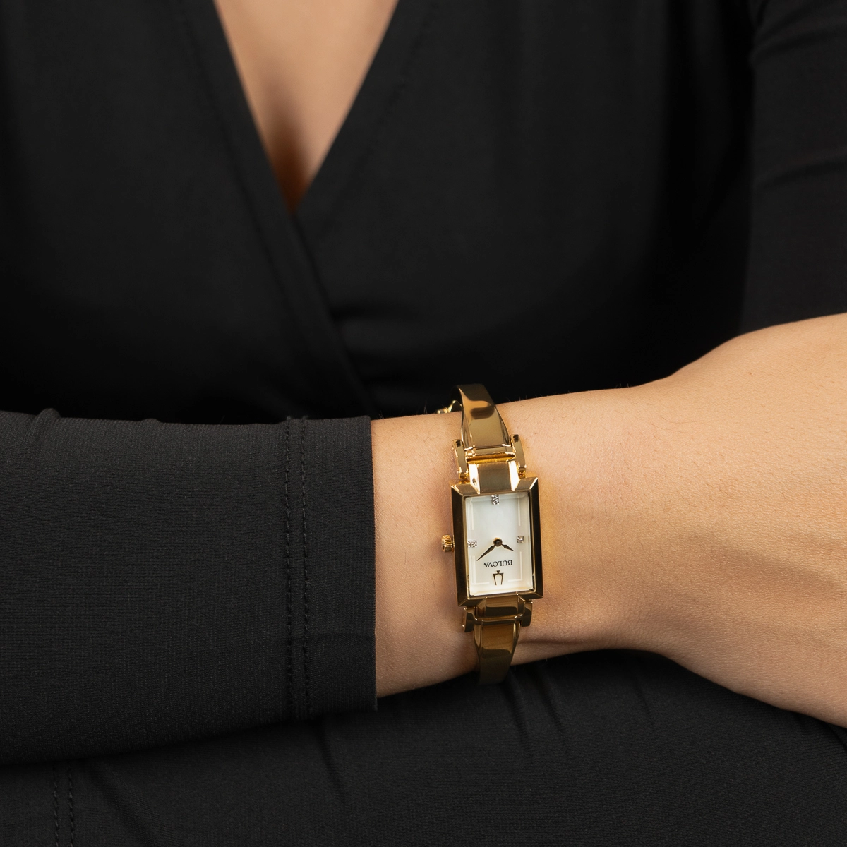 Reloj Bulova analogo, para Dama, tablero rectangular color blanco, estilo puntos, pulso acero color dorado