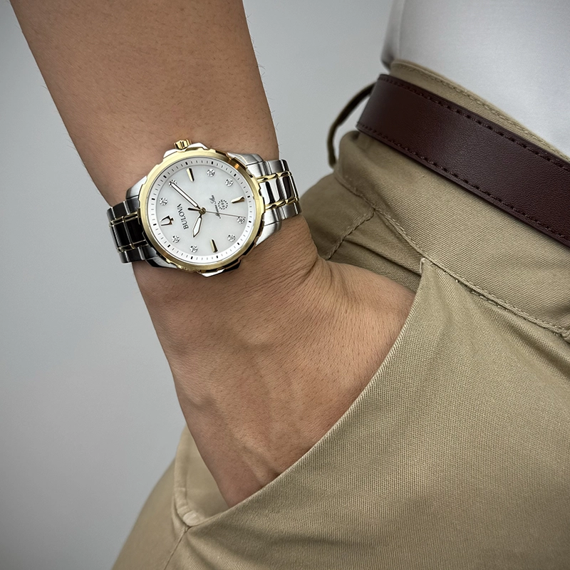 Reloj Bulova análogo, para Dama, tablero redondo color blanco, estilo index + puntos, pulso acero colores plateado y dorado