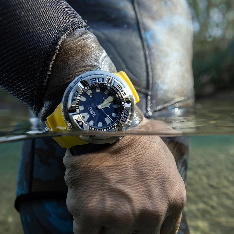 Reloj Citizen analogo, para Hombre, tablero redondo colores azul y blanco, estilo index, pulso silicona color amarillo, calendario