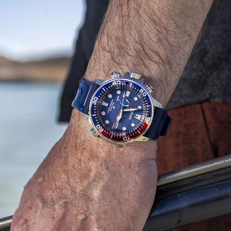 Reloj Citizen análogo, para Hombre, tablero redondo colores azul y rojo, estilo index + puntos, pulso silicona color azul, calendario