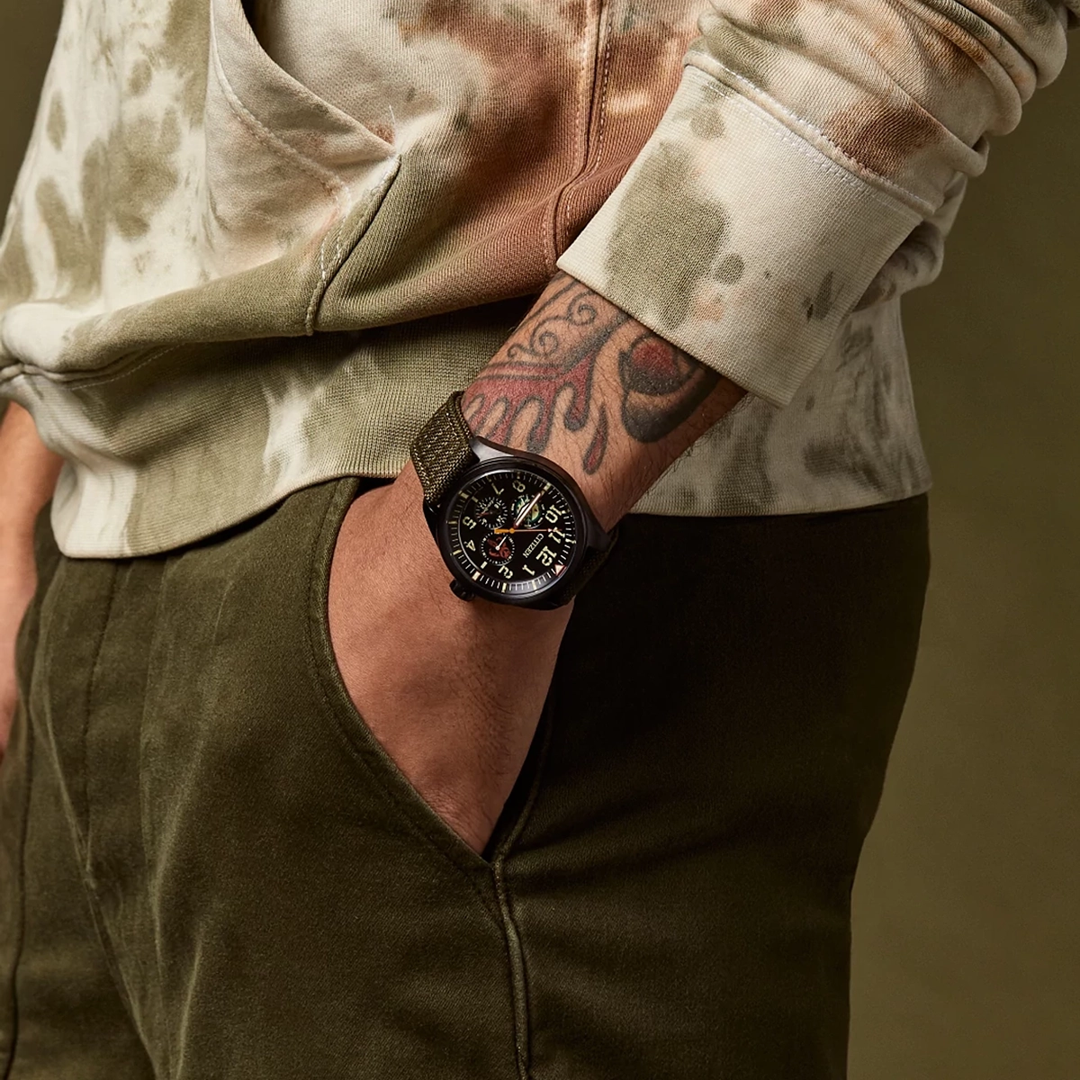 Reloj Citizen análogo, para Hombre, tablero redondo color negro, estilo arábigos, pulso lona color verde, calendario