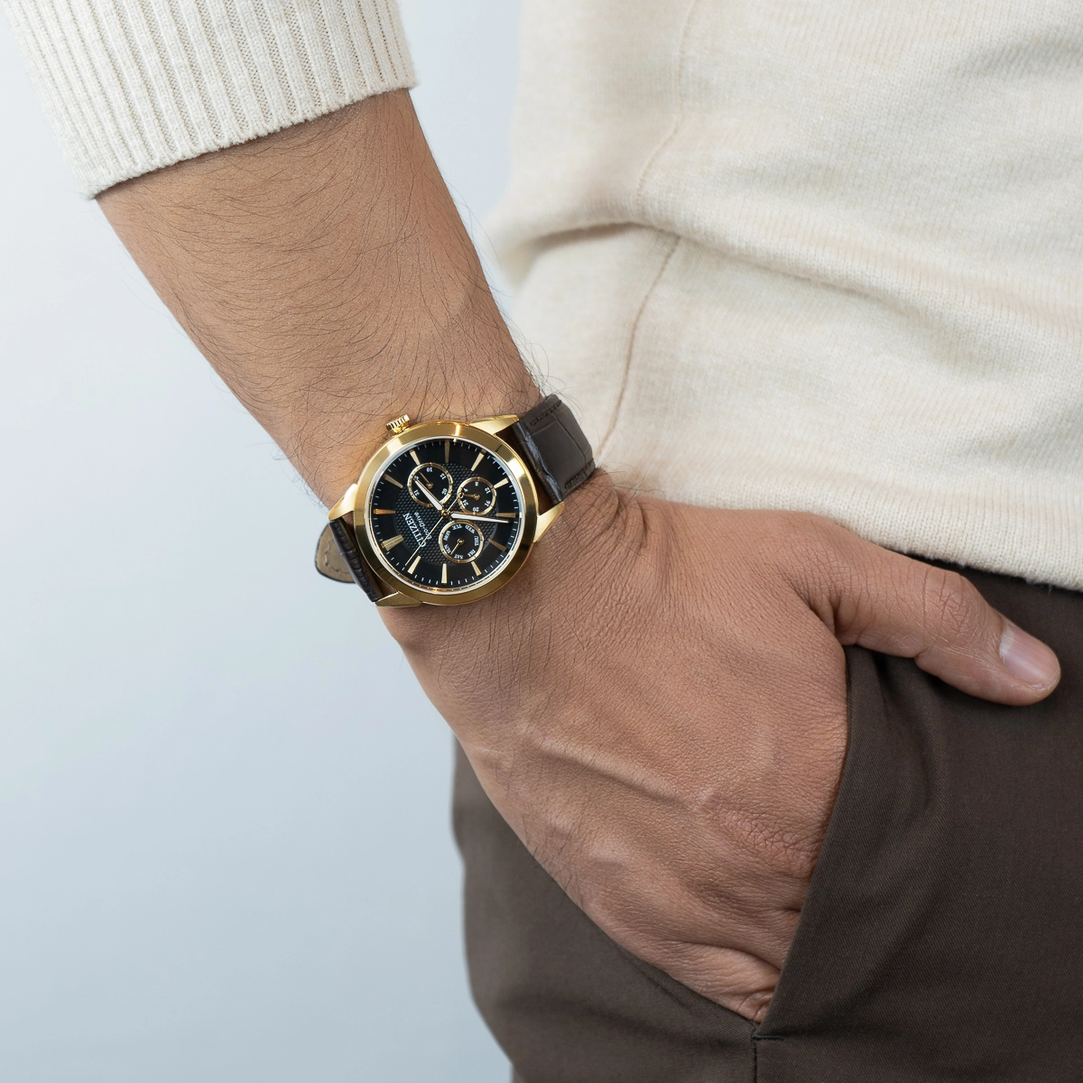 Reloj Citizen analogo, para Hombre, tablero redondo colores negro y dorado, estilo index, pulso cuero color café, calendario