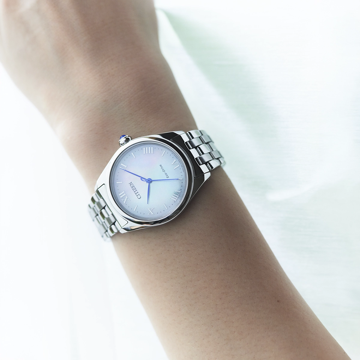 Reloj Citizen análogo, para Dama, tablero redondo color blanco, estilo index + romano, pulso acero color plateado